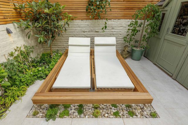 Garden design Vauxhall South London outdoor space, hidden LED strip lighting, polished white pebbles, porcelain paving steps tiles stand slatted cedar trellis.