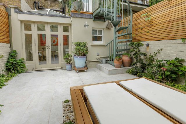 Garden design Vauxhall South London outdoor space, hidden LED strip lighting, polished white pebbles, porcelain paving steps tiles stand slatted cedar trellis.