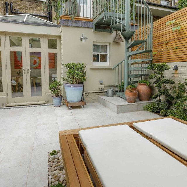 Garden design Vauxhall South London outdoor space, hidden LED strip lighting, polished white pebbles, porcelain paving steps tiles stand slatted cedar trellis.