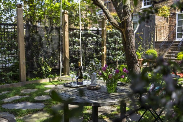 Inspirational city garden design in Holland Park London, Yorkstone stepping stones, oak posts architectural rythm to utilise lower terrace, near the basement.