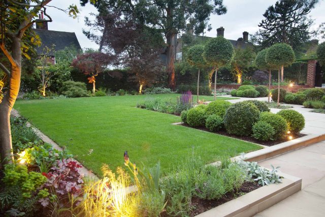 Stunning Suburban Garden constructed in Hampstead by Lynne Marcus also with Hunza exterior lighting illuminates asymmetrical landscape design, stone terrace.