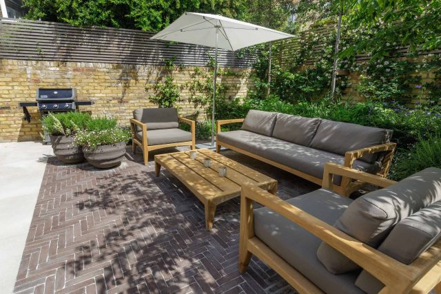 Courtyard Garden Design with an elegant walled space with Yorkstone work Fulham by The Garden Builders, canopy shade for a central lounge planted seating area.