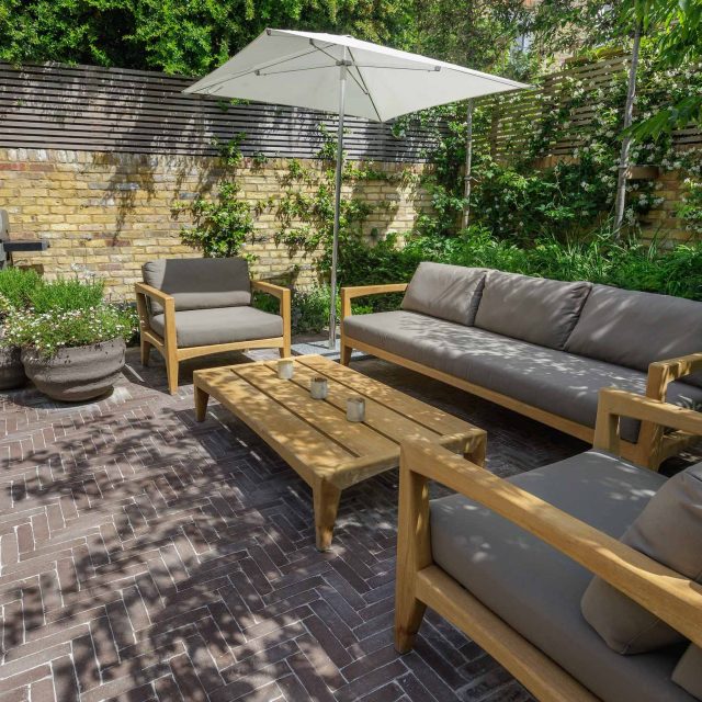 Courtyard Garden Design with an elegant walled space with Yorkstone work Fulham by The Garden Builders, canopy shade for a central lounge planted seating area.