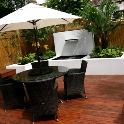 Decking design london elegant walled outdoor entertaining space Wimbledon South West London, lush planting, cozy relaxing outdoor dining area, water feature.