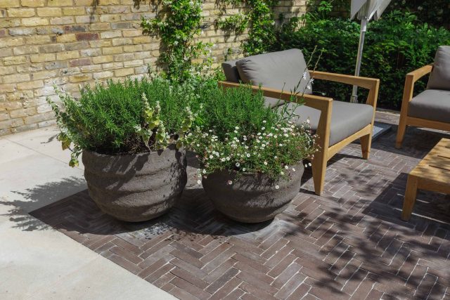Courtyard Garden Design with an elegant walled space with Yorkstone work Fulham by The Garden Builders, canopy shade for a central lounge planted seating area.