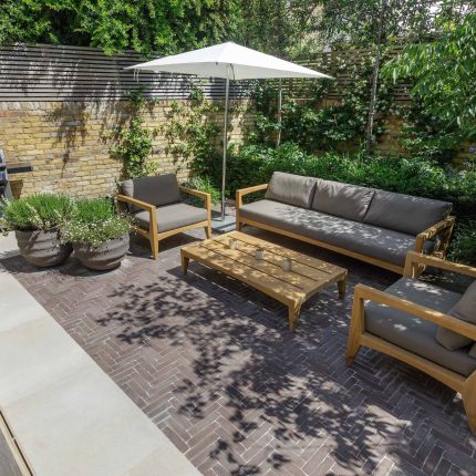 Courtyard Garden Design with an elegant walled space with Yorkstone work Fulham by The Garden Builders, canopy shade for a central lounge planted seating area.
