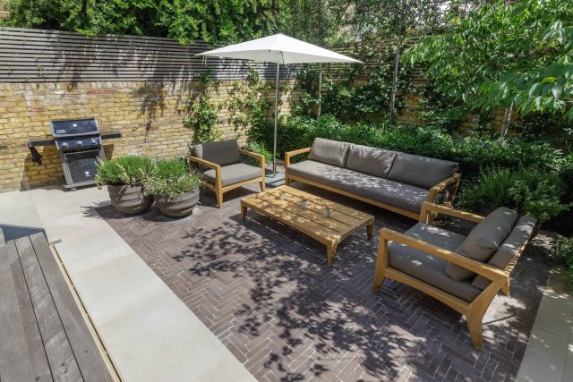 Courtyard Garden Design with an elegant walled space with Yorkstone work Fulham by The Garden Builders, canopy shade for a central lounge planted seating area.