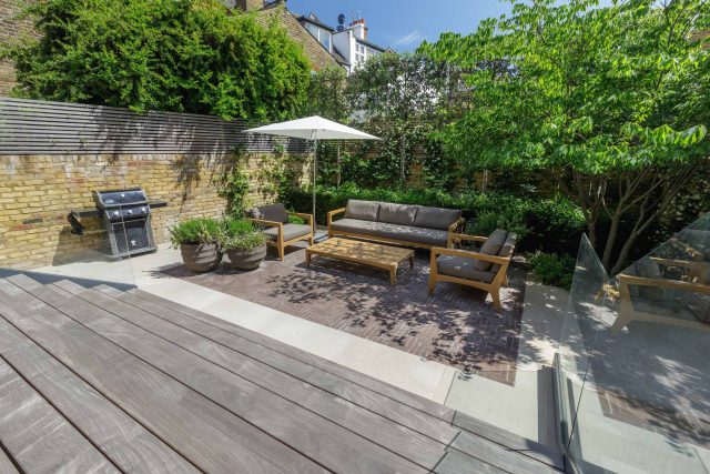 Courtyard Garden Design with an elegant walled space with Yorkstone work Fulham by The Garden Builders, canopy shade for a central lounge planted seating area.