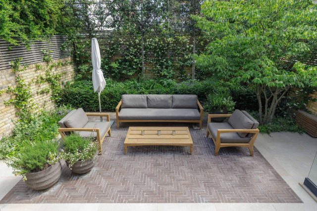 Courtyard Garden Design with an elegant walled space with Yorkstone work Fulham by The Garden Builders, canopy shade for a central lounge planted seating area.