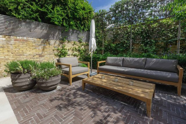Courtyard Garden Design with an elegant walled space with Yorkstone work Fulham by The Garden Builders, canopy shade for a central lounge planted seating area.