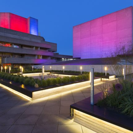Illuminated wooden planters with alliums and grasses on the brutalist South Bank.
