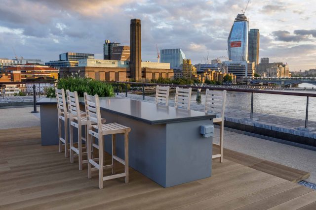 Large Central London commercial roof terrace design, timber benches, planters, artificial lawn, mixed planting outdoor hospitality event space designers London.