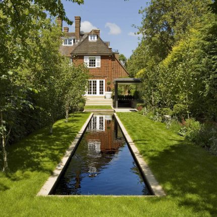 Stunning Suburban Garden constructed in Hampstead by Lynne Marcus also with Hunza exterior lighting illuminates asymmetrical landscape design, stone terrace.