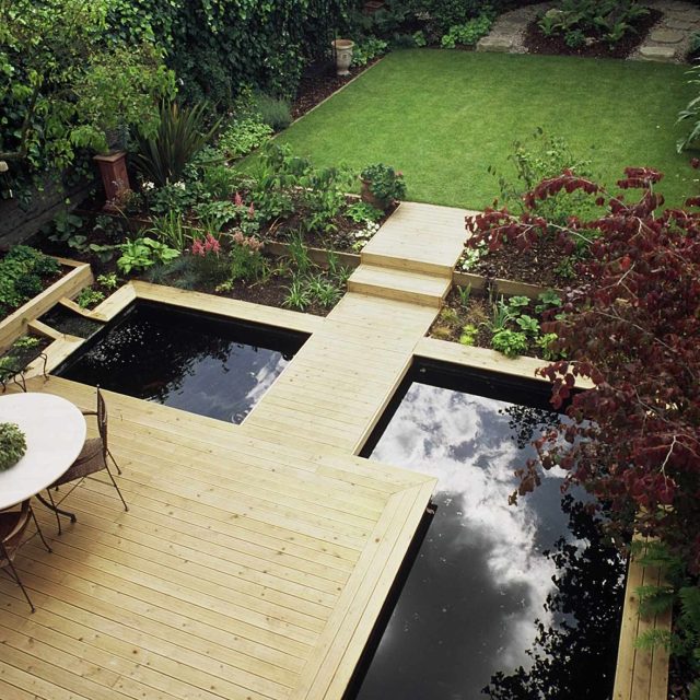 Contemporary Softwood Deck Garden Builders consultants produce in St John's Wood with pool a floating bridge leading to steps running up to the lawned area.