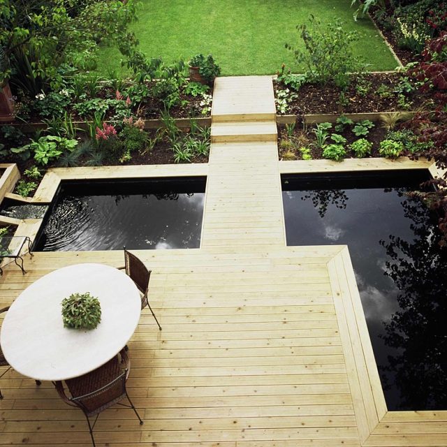 Contemporary Softwood Deck Garden Builders consultants produce in St John's Wood with pool a floating bridge leading to steps running up to the lawned area.