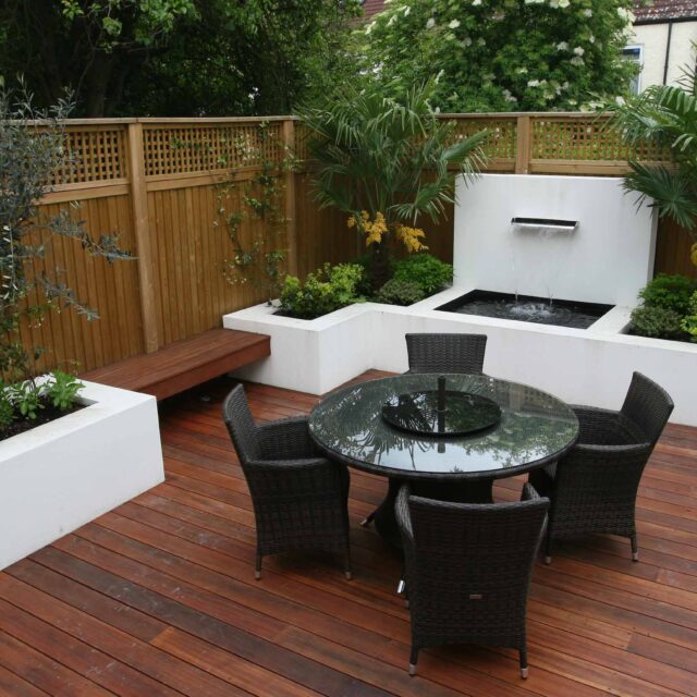 Decking design london elegant walled outdoor entertaining space Wimbledon South West London, lush planting, cozy relaxing outdoor dining area, water feature.