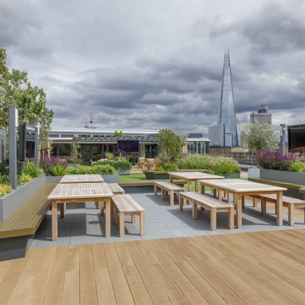 Large Central London commercial roof terrace design, timber benches, planters, artificial lawn, mixed planting outdoor hospitality event space designers London.