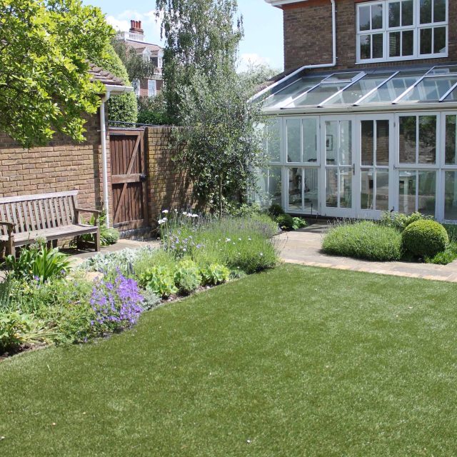 Wimbledon luxury artificial lawn, designed with York stone paving and reclaimed London stock bricks terraces hard landscaping external LED lighting London.
