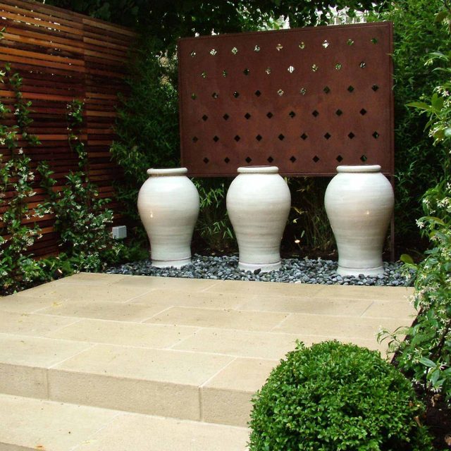 Declan Buckley contemporary small garden Putney a clever design for a space uses pale Blanc de Bierge paving to offset the deep brown cedar sophisticated screen.