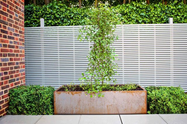 Large garden using Portland stone and steel planters in Hampstead by designer Lynne Marcus, excavation construction hard landscaping specialist in London.