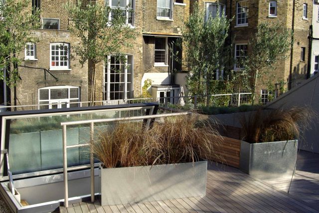 City Roof Terrace Marylebone W1 designed by Joan Edlis of Joan Edlis Associates and built by the Garden Builders decked floor surface, stainless steel planters.
