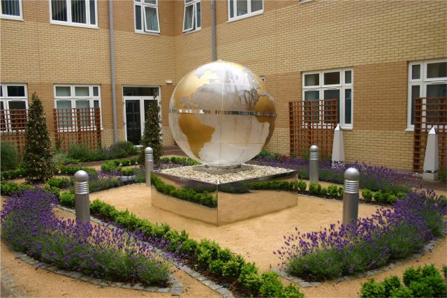 Garden Design Sphere Water Feature set in the courtyard of a London Hospital dynamic steel water feature a clear acrylic sphere included map of the world.