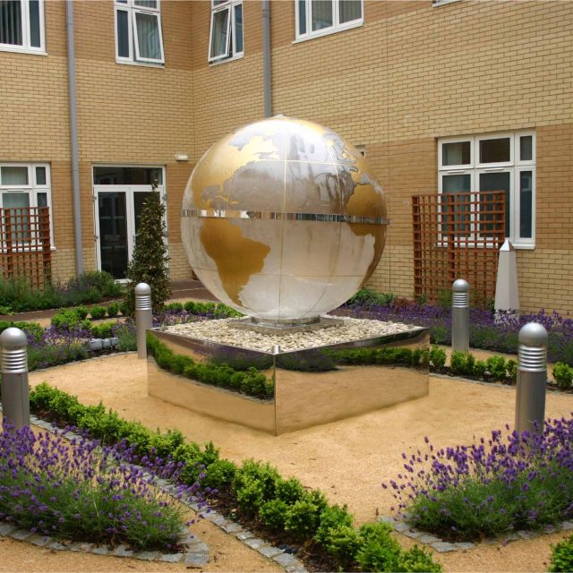 Garden Design Sphere Water Feature set in the courtyard of a London Hospital dynamic steel water feature a clear acrylic sphere included map of the world.