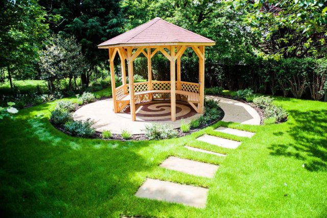 Large suburban garden desigened with York stone dining terrace and timber gazebo in north London, land drainage, lawn, dining terrace, heaters, planting.