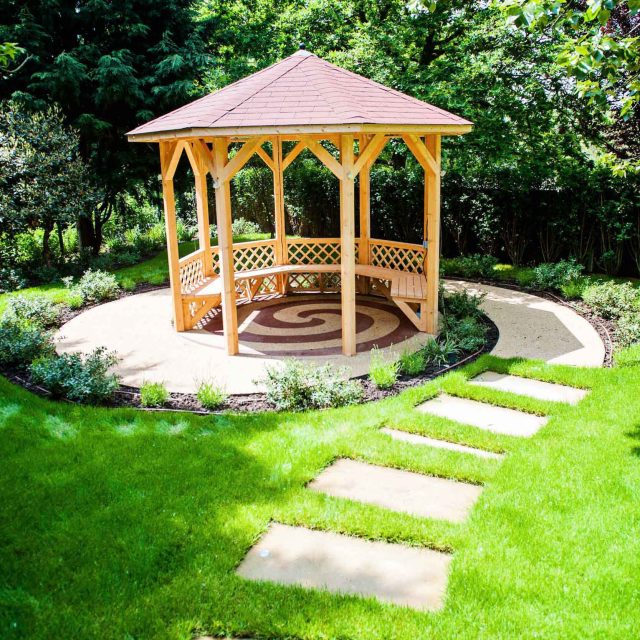 Large suburban garden desigened with York stone dining terrace and timber gazebo in north London, land drainage, lawn, dining terrace, heaters, planting.