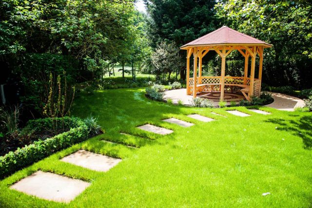 Large suburban garden desigened with York stone dining terrace and timber gazebo in north London, land drainage, lawn, dining terrace, heaters, planting.