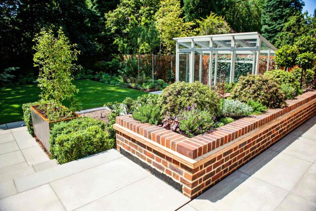 Large garden using Portland stone and steel planters in Hampstead by designer Lynne Marcus, excavation construction hard landscaping specialist in London.