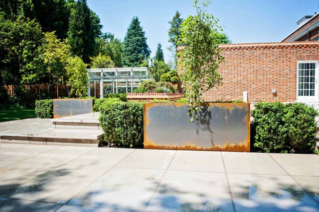 Large garden using Portland stone and steel planters in Hampstead by designer Lynne Marcus, excavation construction hard landscaping specialist in London.