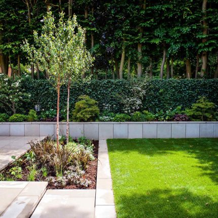 Large garden using Portland stone and steel planters in Hampstead by designer Lynne Marcus, excavation construction hard landscaping specialist in London.