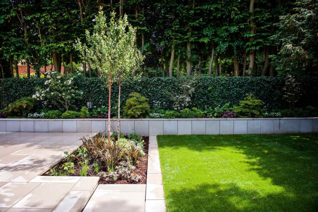 Large garden using Portland stone and steel planters in Hampstead by designer Lynne Marcus, excavation construction hard landscaping specialist in London.