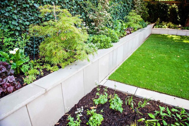 Large garden using Portland stone and steel planters in Hampstead by designer Lynne Marcus, excavation construction hard landscaping specialist in London.