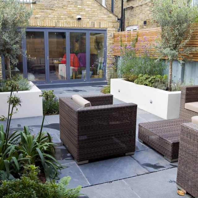 Small Contemporary designed garden consultants Putney with rendered raised beds, slate and basalt paving, timber screening in horizontal slatted design London.