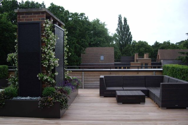 Roof Terrace design in Highgate a bespoke contemporary space with sleek bespoke slate water features steel planters planting olive tree horticulturalist.