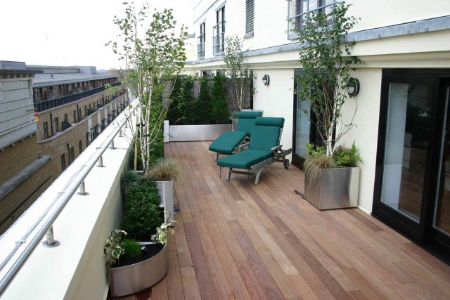 Tower Bridge roof garden terrace design view over the Thames and Bridge in London, huge stainless steel water, robust planting, curved Yew hedge LED lighting.