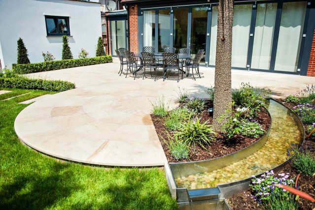 Large suburban garden desigened with York stone dining terrace and timber gazebo in north London, land drainage, lawn, dining terrace, heaters, planting.
