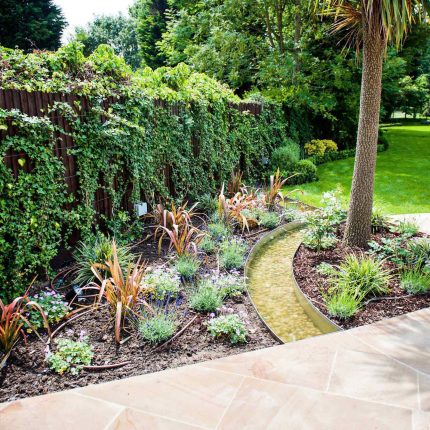 Large suburban garden desigened with York stone dining terrace and timber gazebo in north London, land drainage, lawn, dining terrace, heaters, planting.