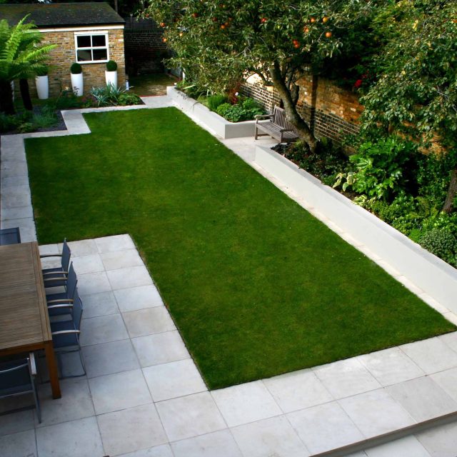 Modern Family Garden in Battersea with patio lighting planting and machined sandstone pathway specialist company stone work, planting herbaceous perennials.