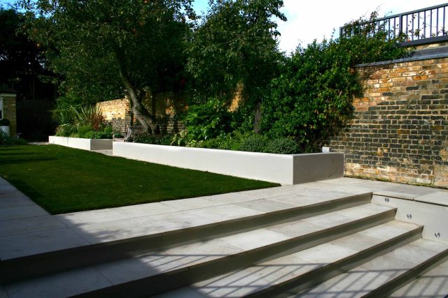 Modern Family Garden in Battersea with patio lighting planting and machined sandstone pathway specialist company stone work, planting herbaceous perennials.