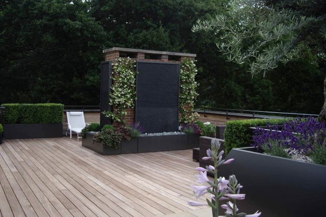 Roof Terrace design in Highgate a bespoke contemporary space with sleek bespoke slate water features steel planters planting olive tree horticulturalist.