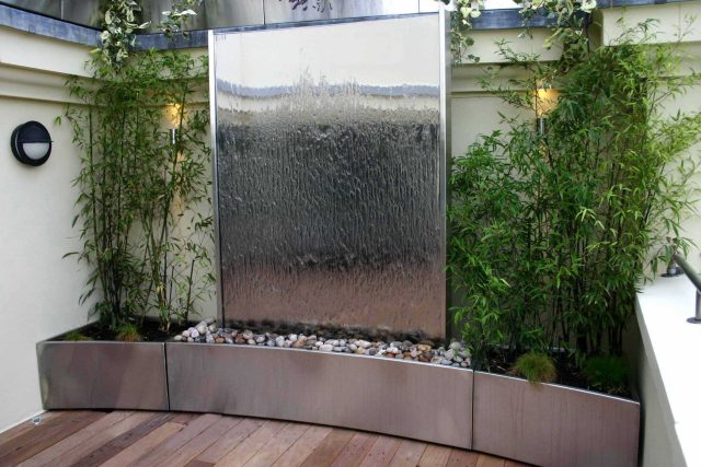 Tower Bridge roof garden terrace design view over the Thames and Bridge in London, huge stainless steel water, robust planting, curved Yew hedge LED lighting.