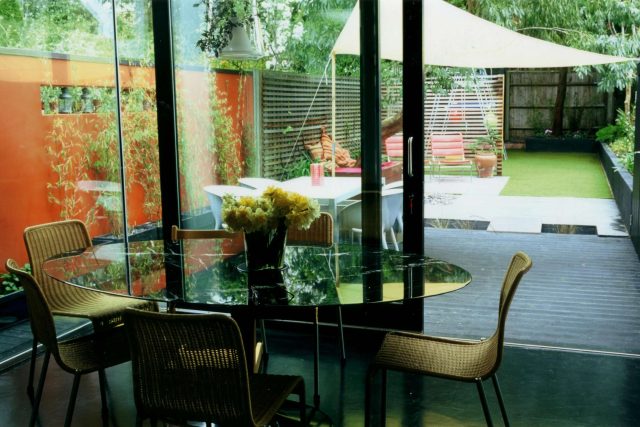 Child friendly synthetic lawn designed as a low-maintenance, contemporary and colourful space, planted raised beds slate terrace hardwood tree seat specialists.