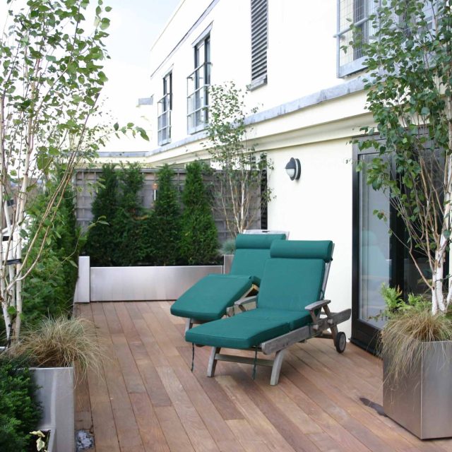 Tower Bridge roof garden terrace design view over the Thames and Bridge in London, huge stainless steel water, robust planting, curved Yew hedge LED lighting.