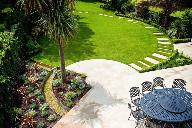 Large suburban garden desigened with York stone dining terrace and timber gazebo in north London, land drainage, lawn, dining terrace, heaters, planting.