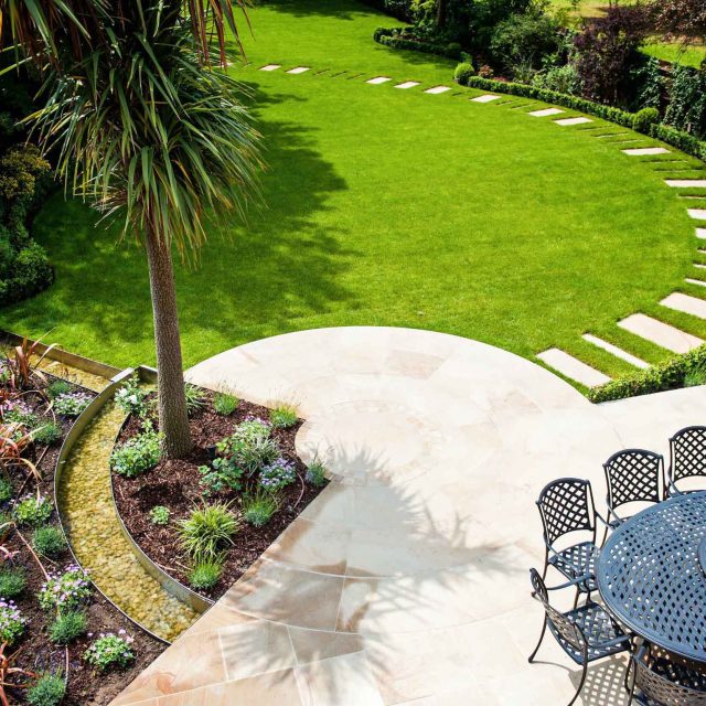 Large suburban garden desigened with York stone dining terrace and timber gazebo in north London, land drainage, lawn, dining terrace, heaters, planting.