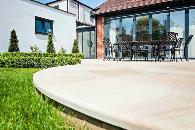 Large suburban garden desigened with York stone dining terrace and timber gazebo in north London, land drainage, lawn, dining terrace, heaters, planting.