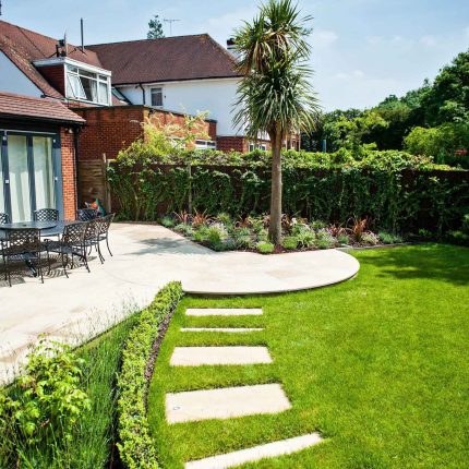 Large suburban garden desigened with York stone dining terrace and timber gazebo in north London, land drainage, lawn, dining terrace, heaters, planting.
